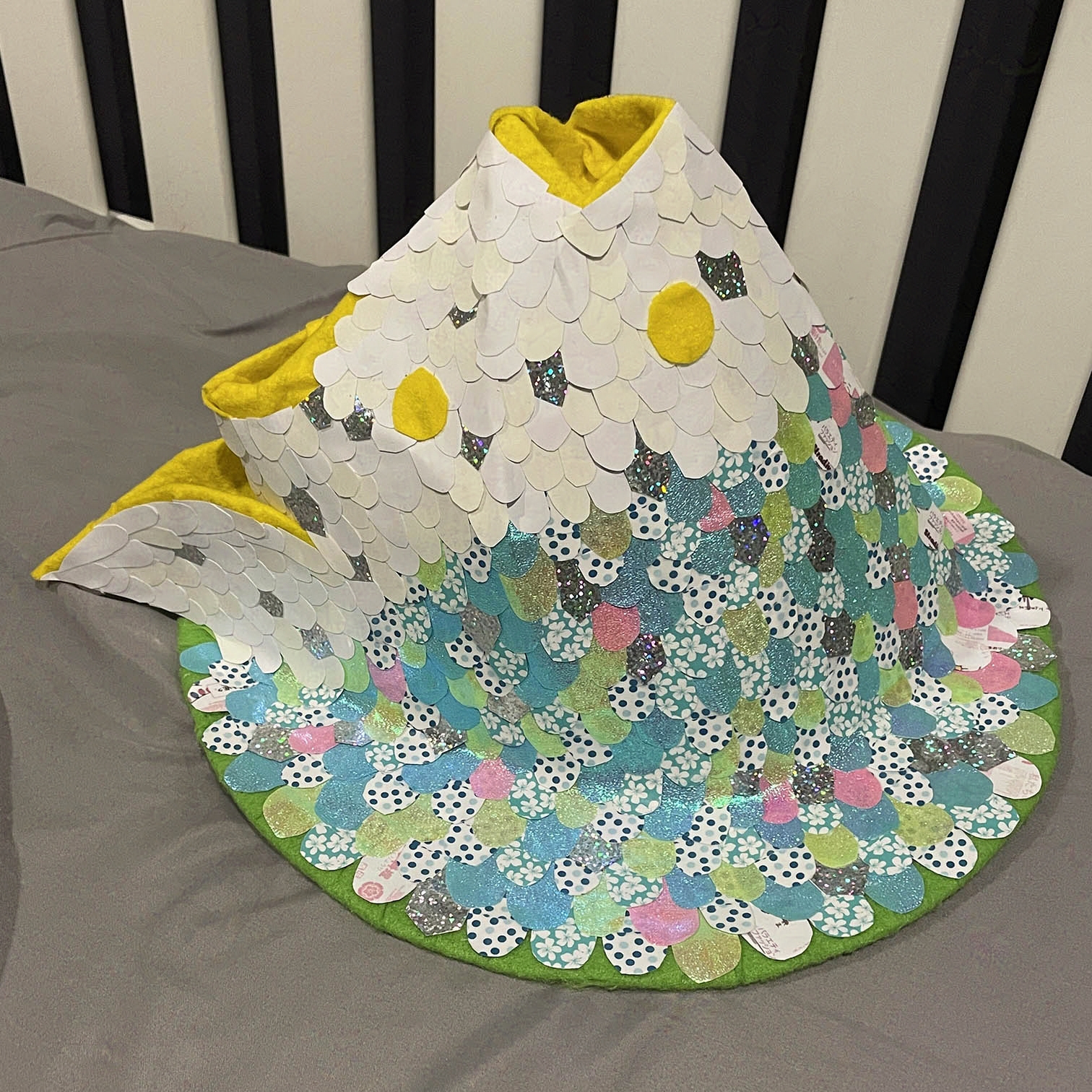 Hat left side. Scales predominantly blue color.
