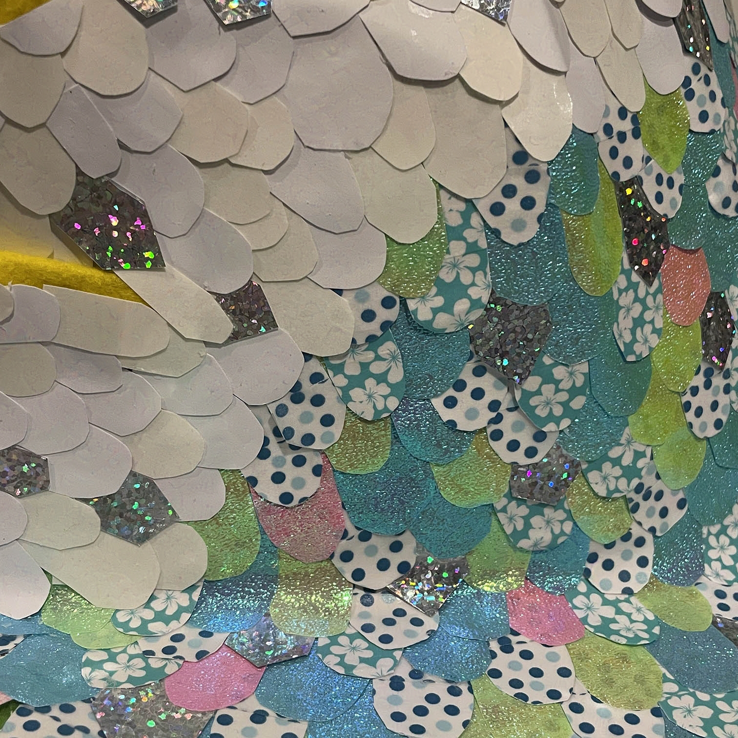 Close-up of iridescent paper scales. Some have blue polka dot patterns.