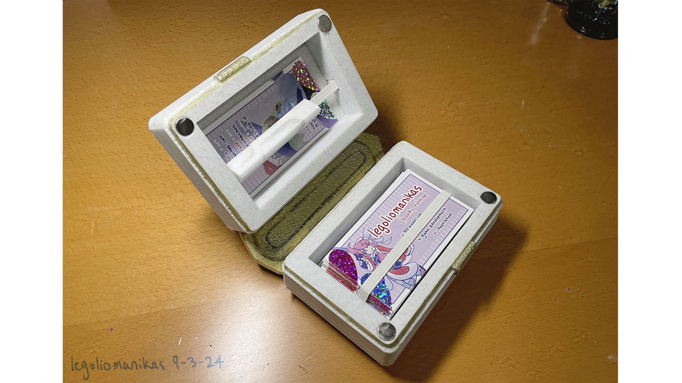 Interior of book, showing openings on both covers to store business cards. Card is held in place with a horizontal elastic band. 